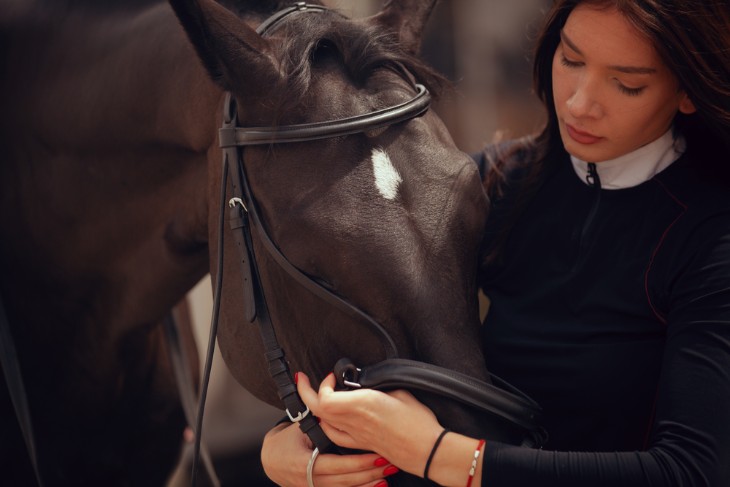 Young girl petting her horse